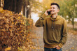 © anatoliycherkas - Portrait of handsome and happy guy smiling and talking on the phone in the autumn park