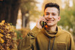 © anatoliycherkas - Portrait of handsome and happy guy smiling and talking on the phone in the autumn park