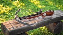 Loaded Crossbow On A Wooden Bench. Selective Focus.