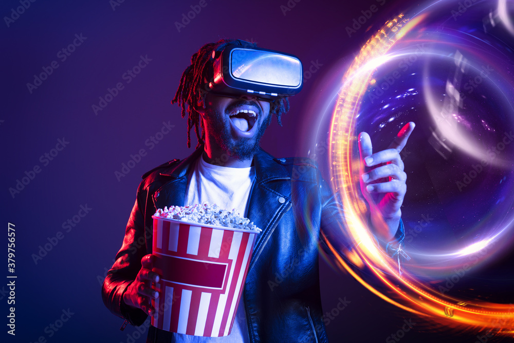 Man with VR glasses and popcorn watches a 3D film - obrazy, fototapety, plakaty 