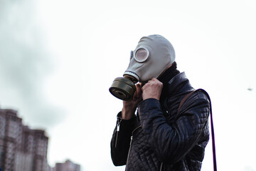 Wall Mural - young man wearing a gas mask on a city street