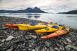 Double kayaks parked on the bay on scenic mountain ocean bay during arctic expedition