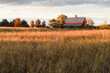 © Deirdre Malfatto/Stocksy - red barn or stable in a field of dry grass in autumn