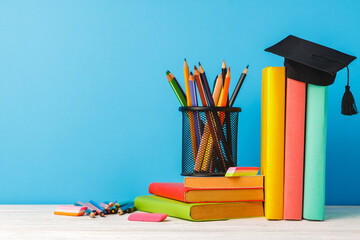 Cup of color pencils and stack of books