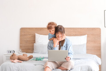 Sticker - Working mother with little son in bedroom at home