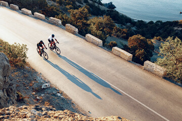 two professional male cyclists riding their racing bicycles in the morning together