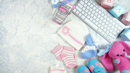 Wall Mural - Baby nursery clothing mom bloggers desktop workspace with accessories and shopping cart on white textured background. Top view blog hero header creative composition flat lay. Negative copy space.
