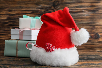 Santa hat and Christmas gifts on wooden background