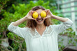 © zinkevych - Woman in white holding two lemons and feeling cheerful