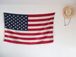 © Jeremy Pawlowski/Stocksy - American flag and straw hat hanging on wall of bedroom as decoration