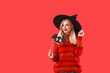 © Pixel-Shot - Beautiful young witch on color background. Halloween celebration