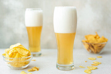 lager beer with spicy potato chips in tall glasses