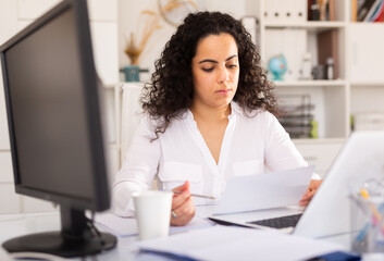 Wall Mural - Confident businesswoman in formal wear working on laptop in business office