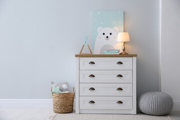 Poster - Modern white chest of drawers near light wall in child room, space for text. Interior design