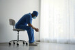 © New Africa - Exhausted doctor sitting on chair indoors, space for text. Stress of health care workers during COVID-19 pandemic
