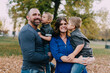 © Chelsea Victoria/Stocksy - A young family posing for portraits in the fall