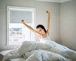 © Duet Postscriptum/Stocksy - Young woman waking up and stretching