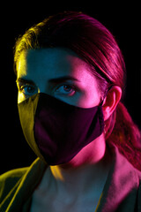 Wall Mural - health, safety and pandemic concept - young woman wearing reusable protective mask over black background