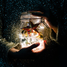 Hands Holding Christmas Decoration Light In The Glass Jar
