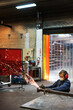 © Jetta Productions/Stocksy - Female factory worker creates a spray of sparks
