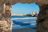 Fototapeta Natura - View at Cádiz, old historical town, through stone window in ruined wall, Andalusia, Spain.