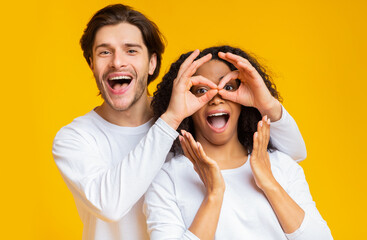 Wall Mural - Man making funny glasses with fingers to his girlfriend