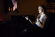 © Danil Nevsky/Stocksy - Girl with mug switching channels in darkness