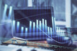 © peshkova - Forex graph hologram on table with computer background. Multi exposure. Concept of financial markets.
