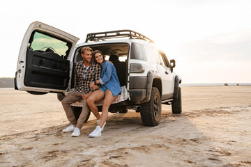 Smiling young couple sitting in car