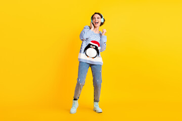 Full size photo of pretty youngster attractive lady party newyear listen cool modern technology earphones disco event wear ugly sweater pullover jeans shoes isolated yellow color background