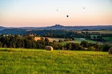 Countryside With Castle Trosky And Ballons In Sunset.