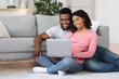 © Prostock-studio - Loving pregnant african american couple using laptop at home