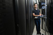 © Jetta Productions/Stocksy - Technician types at a monitoring station in a server room
