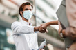 © Mediteraneo - Business people shake hand no touch concept new normal social distancing,outdoor