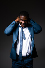 Wall Mural - An African American man stands in a business suit and puts a tie over his head. standing on a gray background