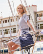 Young beautiful blonde model in fashionable clothes at the yacht club. Street modern womens fashion