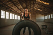 © Jacob Lund - Muscular female working out with big tire