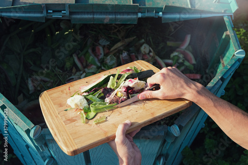 Fotografía Person throws organic waste from his kitchen into compost heap