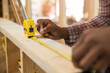 © SuperStock - Worker measuring wood at construction site