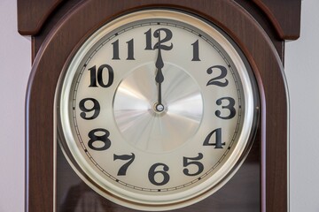 Close up macro view of brown clock with light clock face showing  twelve  o'clock. Time concept. Postcard. Beautiful christmas backgrounds.