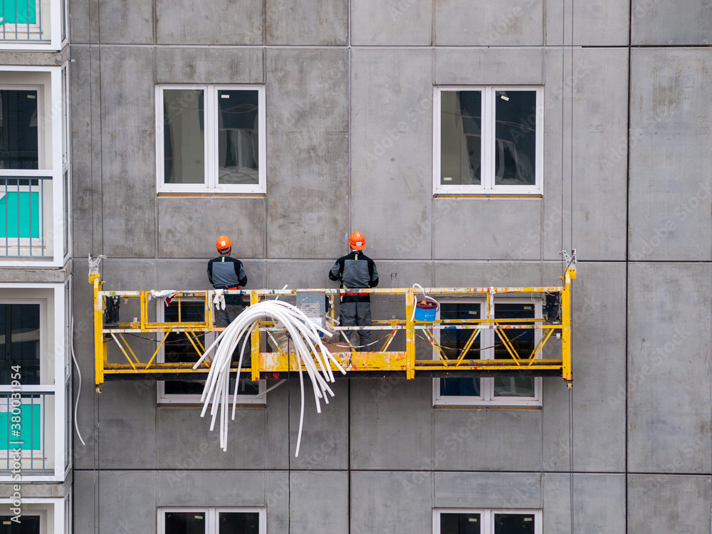 high-rise workers work on the lift in the construction of high-rise ...