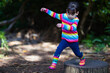 © M-image - young girl jumping between the timber in the forest park