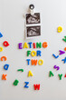 © Amanda Large/Stocksy - Fetal ultrasound image and magnetic letters on a fridge
