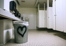 Gender Neutral Restroom With A Heart Spray Painted On The Trash Can