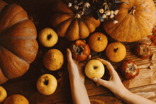 Background Of Pumpkins, Apples And Persimmons. Autumn Harvest On A Wooden Table. Vegetables And Fruits In Your Hands. The Concept Of Thanksgiving, Harvest Festival.