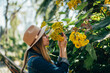 © JAVIER PARDINA/Stocksy - woman sniffing flowers in the park