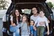 © Kristin Rogers Photography/Stocksy - happy Family eating donuts in car