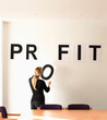 © Hugh Sitton/Stocksy - Businesswoman in office sticking letters onto the wall