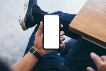 cell phone mockup blank white screen.woman hand holding texting using mobile on desk at coffee shop.background empty space for advertise.work people contact marketing business,technology