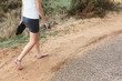 © Jacqui Miller/Stocksy - Legs of teenage girl, wearing a short skirt, walking barefoot along a road